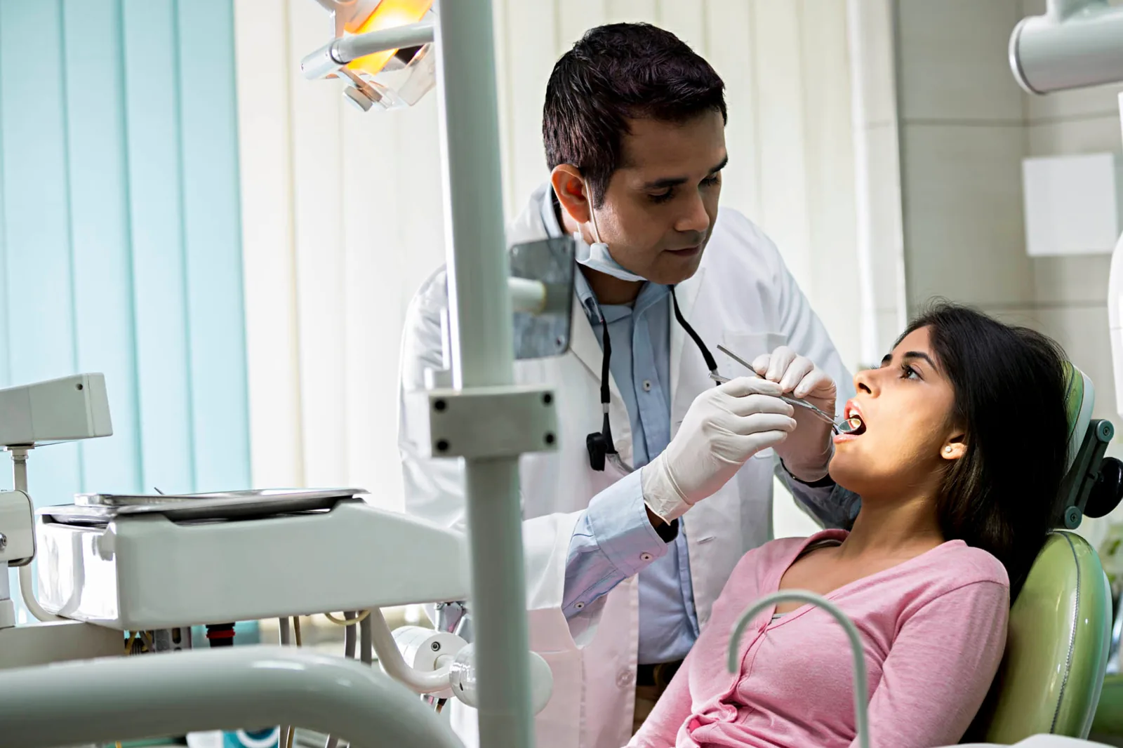 A dentist examining a patient in the chair at an Indian dental clinic
